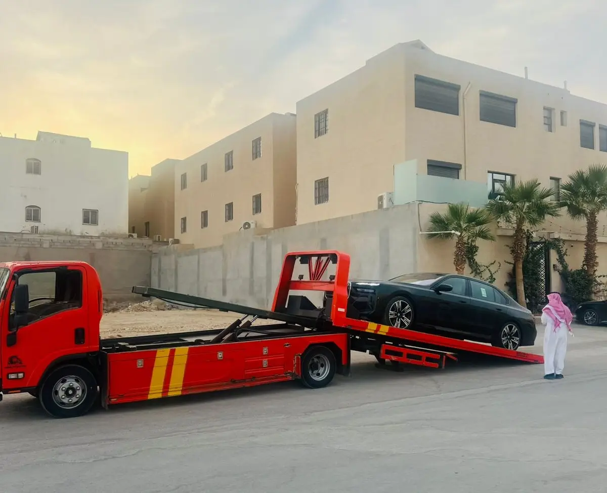 سطحة هيدروليك حمراء تنقل سيارة BMW فاخرة في الخرج